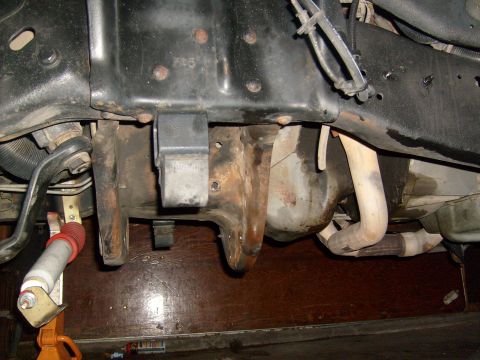 1986 Ford Bronco - Underside view of vehicle chassis and suspension parts, showing frame rails and exhaust pipes.