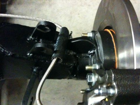 Suzuki Samurai - Close-up view of a vehicle's rear axle assembly, showing brake components and a metal brake line.