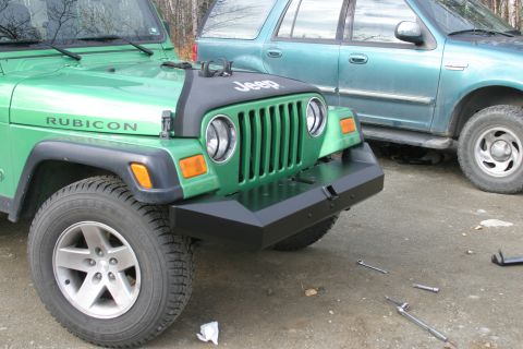 1987 Suzuki Samurai - A green Jeep Wrangler Rubicon is parked next to a teal SUV, with tools scattered on the ground.