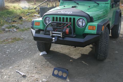 1987 Suzuki Samurai - This green Jeep Wrangler features an aftermarket bumper and a winch mounted on the front.