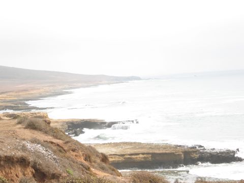 1986 Ford Bronco - Coastal landscape with ocean waves and cliffs, a scenic view.