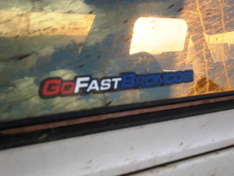 1986 Ford Bronco - A sticker on the window of a vehicle reads "Go Fast Broncos" with a red, white, and blue design.