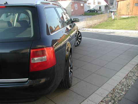 2003 Audi A6 - A black 2003 Audi A6 station wagon is parked on a paved driveway with a residential background.
