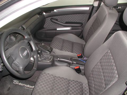 2003 Audi A6 - The interior of this 2003 Audi A6 features checkered cloth seats and a leather-wrapped steering wheel.