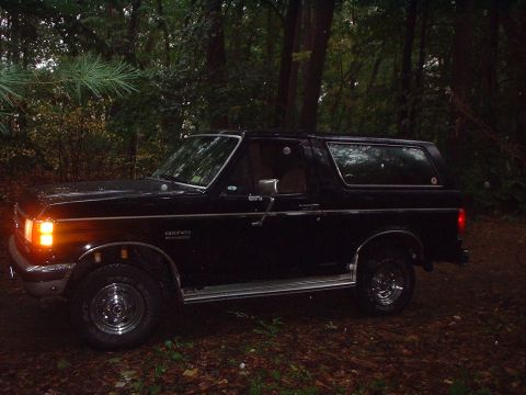 1989 Ford Bronco - This 1989 Ford Bronco is parked off-road in a forest setting.