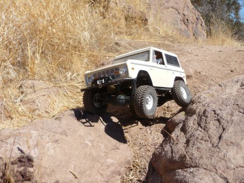 1988 Ford Bronco - RC rock crawler navigating a steep, rocky incline in a dry, arid environment.