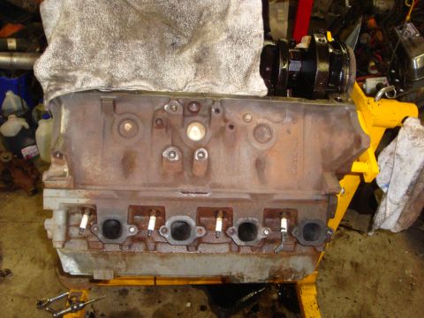 1989 Ford Bronco - Engine block with spark plugs installed, shown in a workshop setting.