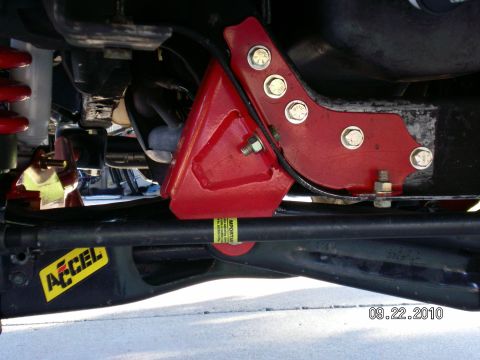 1996 Ford Bronco - Close-up view of aftermarket suspension components and an Accel sticker on a vehicle's undercarriage.