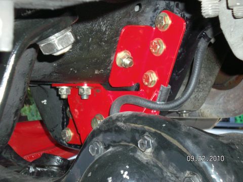 1996 Ford Bronco - Close-up view of aftermarket suspension modifications on a vehicle's undercarriage.