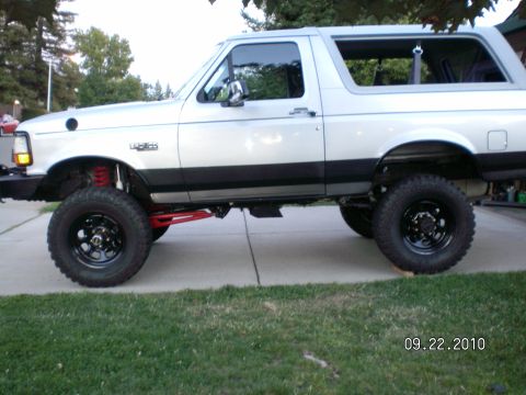 1996 Ford Bronco - This lifted Ford Bronco is shown from the side, parked on a driveway.