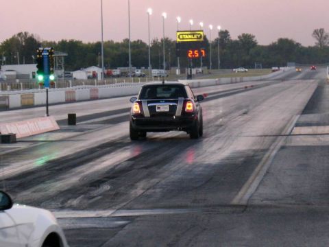 2010 MINI Cooper - A MINI Cooper is on a drag strip at dusk, with a large digital timer in the background.