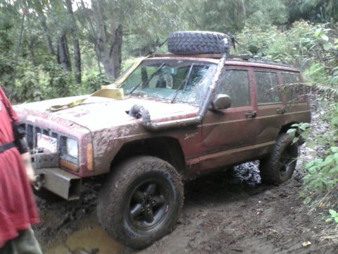 1998 Jeep Cherokee - This 1998 Jeep Cherokee is equipped for off-roading and is currently navigating a muddy trail.
