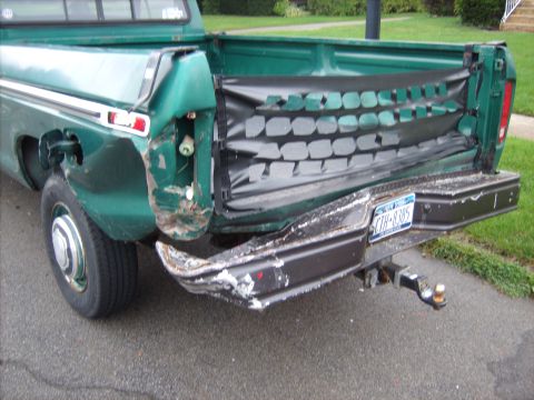 1979 Ford F-250 - Rear view of a green 1979 Ford F-250 pickup truck showing damage to the bumper and tailgate.