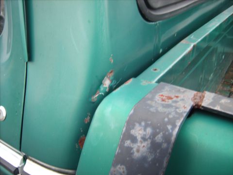 1979 Ford F-250 - Close-up of a green truck's fender and trim shows areas of rust and wear.