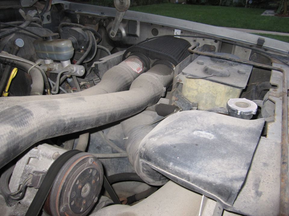 Engine bay of a 1990 Ford Bronco with a K&N air filter and dusty components