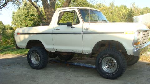 1978 Ford Bronco - This 1978 Ford Bronco is seen from a three-quarter front angle, parked on a paved surface with trees in the background.