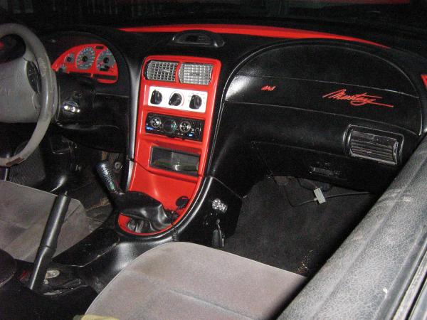 1994 Ford Mustang interior with red accents on the dashboard and center console