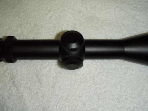 2004 Harley-Davidson Fat Boy - A black rifle scope is shown on a textured background, with visible turrets and lens adjustments.