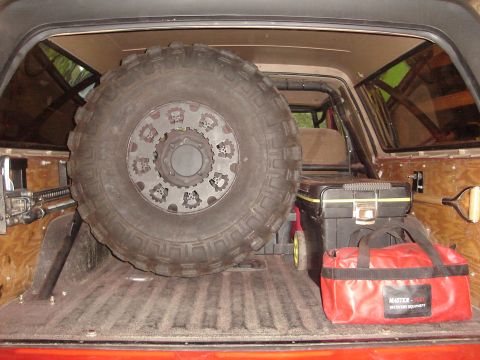 1989 Ford Bronco - Spare tire and recovery gear stored in the cargo area of a vehicle.
