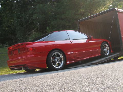 1994 Ford Probe - A red 1994 Ford Probe is driven onto a trailer, its sporty design evident.