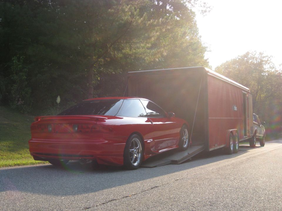 Red 1994 Ford Probe being loaded into a trailer
