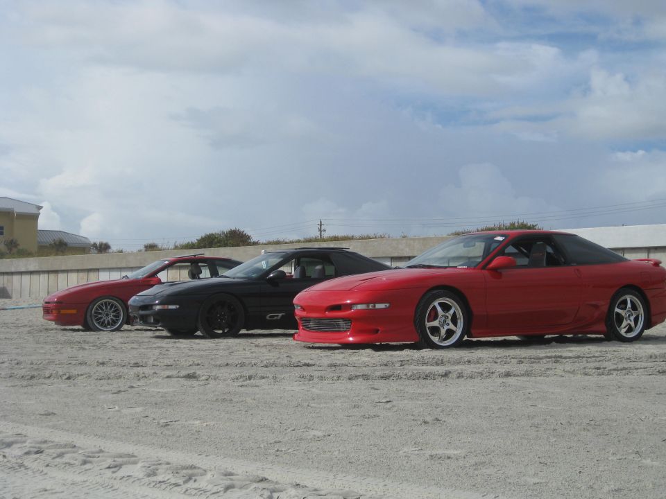 Red 1994 Ford Probe in three-quarter front view on beach