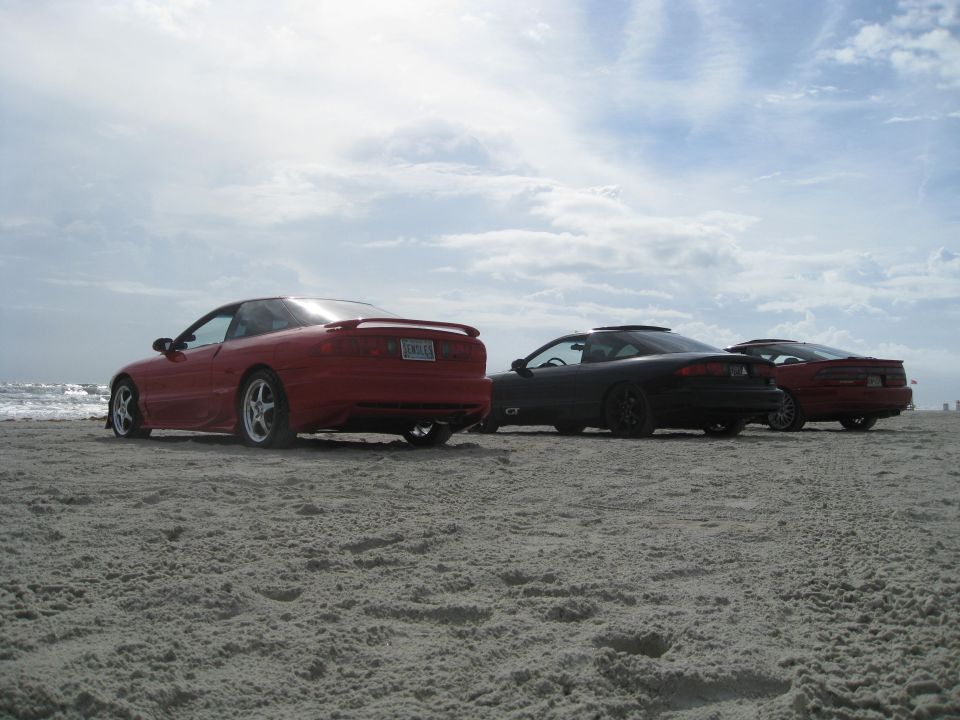 Red 1994 Ford Probe rear view on beach