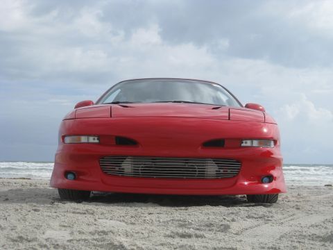 1994 Ford Probe - Front view of a red 1994 Ford Probe parked on a beach.
