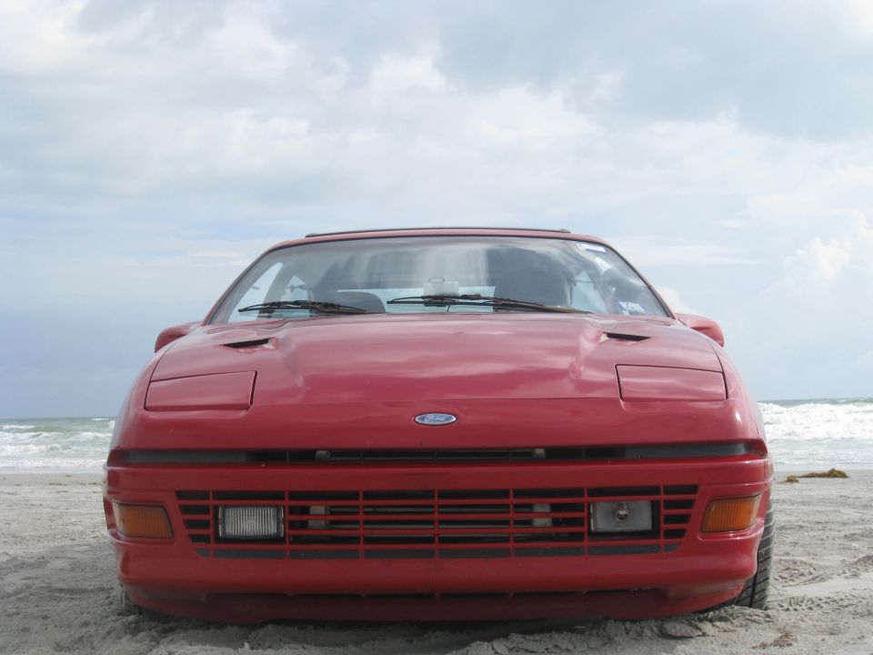 Red 1994 Ford Probe front view on a beach