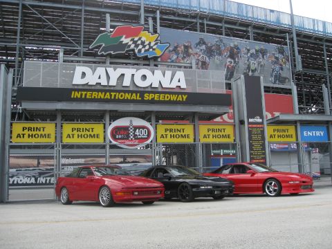 1994 Ford Probe - Three sports cars are parked in front of the Daytona International Speedway entrance.