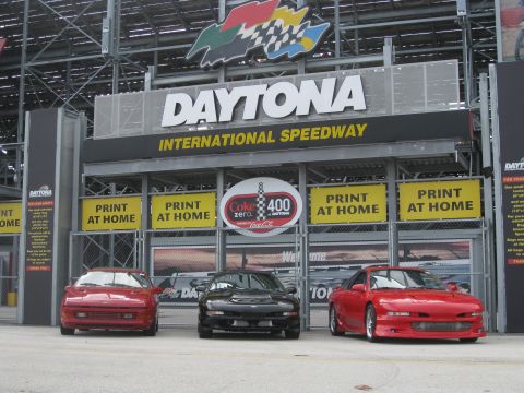 1994 Ford Probe - Three sports cars are parked in front of the Daytona International Speedway entrance.
