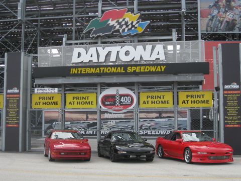 1994 Ford Probe - Three sports cars are parked in front of the Daytona International Speedway entrance.