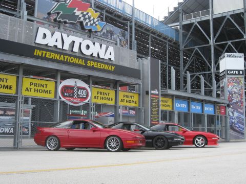 1994 Ford Probe - Three sports cars are parked in front of the Daytona International Speedway entrance.
