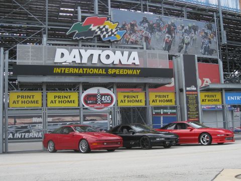 1994 Ford Probe - Coupes are parked in front of the Daytona International Speedway entrance.