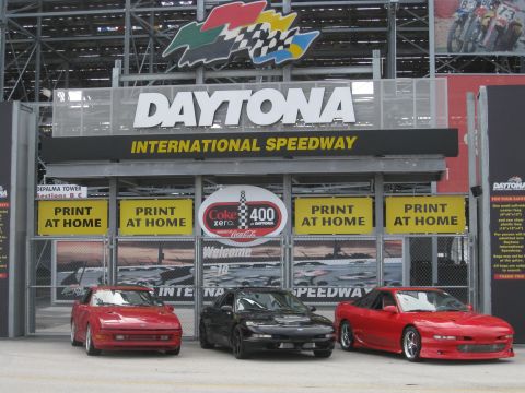 1994 Ford Probe - Three coupes are parked in front of the Daytona International Speedway entrance.