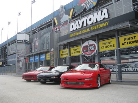1994 Ford Probe - Three sports cars are parked in front of the Daytona International Speedway entrance.
