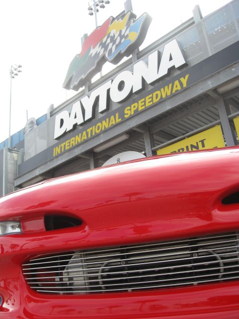 1994 Ford Probe - Front view of a red car with a custom grille, parked in front of the Daytona International Speedway.
