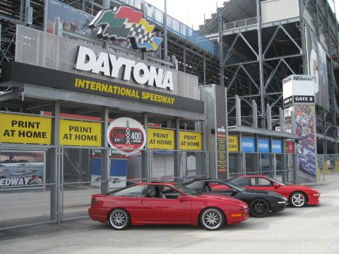 1994 Ford Probe - Three Ford Probes are parked in front of the Daytona International Speedway entrance.