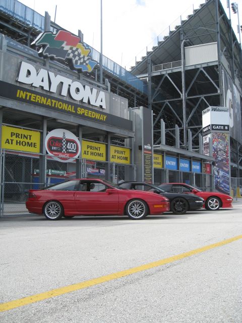 1994 Ford Probe - Cars lined up outside the Daytona International Speedway entrance, with the iconic sign overhead.