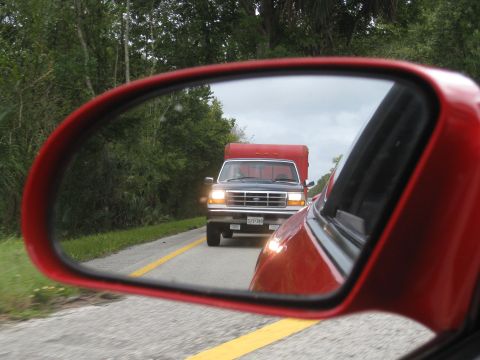 1994 Ford Probe - Reflection in a red car's side mirror shows a red box truck on the road ahead.
