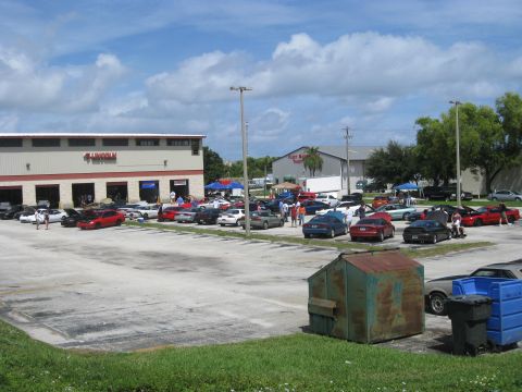 1994 Ford Probe - A gathering of cars in a parking lot, with several vehicles on display and some with their hoods open.