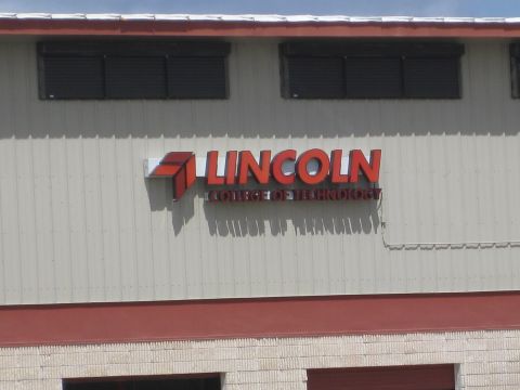 1994 Ford Probe - Exterior signage for Lincoln College of Technology is visible on the building's facade.