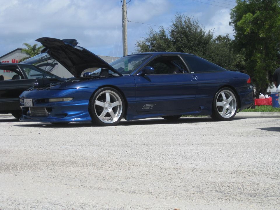 Blue 1994 Ford Probe GT with hood open, parked next to another car
