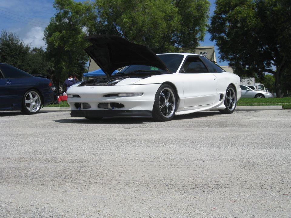 White 1994 Ford Probe with hood open, parked next to a blue car