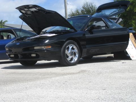 1994 Ford Probe - A black 1994 Ford Probe GT is displayed with its hood and rear hatch open, parked next to another vehicle.