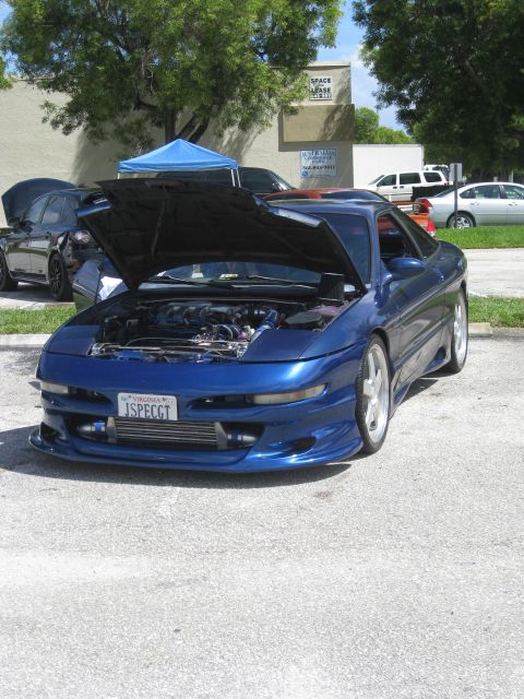 1994 Ford Probe - A blue coupe is parked with its hood open, revealing the engine and an intercooler. Another car is visible behind it.