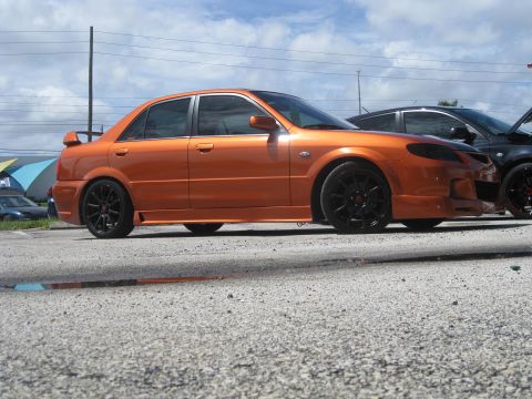 1994 Ford Probe - Side view of an orange sedan with custom wheels and body kit.