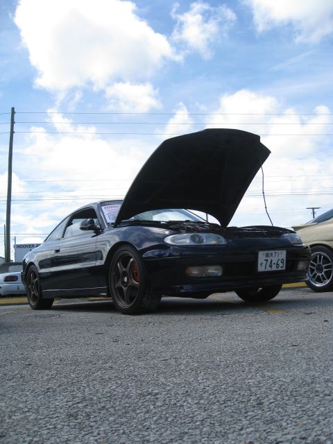 1994 Ford Probe - A black coupe with its hood open displays a Japanese license plate, parked outdoors under a cloudy sky.
