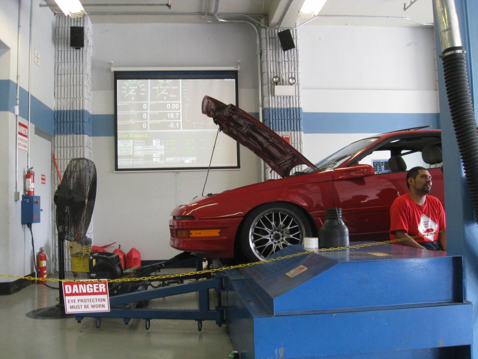 1994 Ford Probe on a dynamometer with hood open, screen displaying data