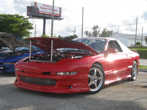 1994 Ford Probe - A red coupe with its hood open, parked next to a blue car also with its hood open.